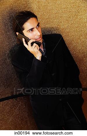Young man dressed in suit, using mobile phone View Large Photo Image Picture - Young man dressed in suit, using mobile phone. Fotosearch