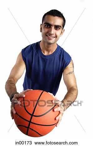 Young man holding basketball forward, looking at camera View Large Photo Image Stock Image - Young man holding basketball forward, looking at camera. Fotosearch