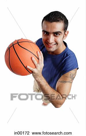 Young man holding basketball, looking at camera View Large Photo Image Stock Image - Young man holding basketball, looking at camera. Fotosearch