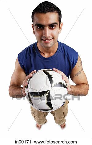 Young man holding soccer ball, looking at camera View Large Photo Image Stock Image - Young man holding soccer ball, looking at camera. Fotosearch