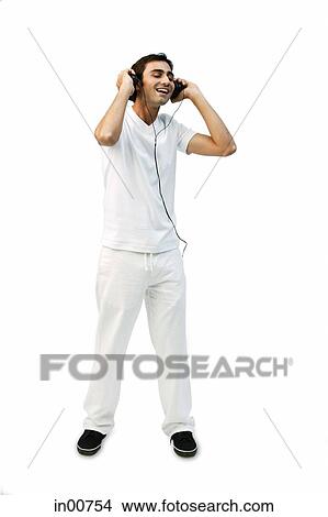 Young man listening to headphones, eyes closed, smiling View Large Photo Image Picture - Young man listening to headphones, eyes closed, smiling. Fotosearch