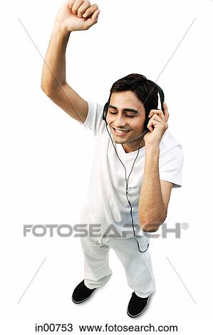 Young man listening to headphones, eyes closed, arms raised View Large Photo Image Stock Image - Young man listening to headphones, eyes closed, arms raised. Fotosearch