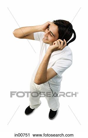 Young man listening to headphones View Large Photo Image Stock Image - Young man listening to headphones. Fotosearch