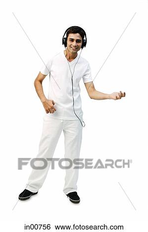 Stock Photograph - Young man listening to headphones, playing air guitar. Fotosearch