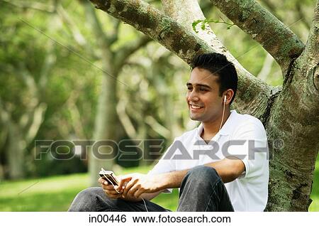 Young man listening to music with headphones View Large Photo Image Stock Photograph - Young man listening to music with headphones. Fotosearch