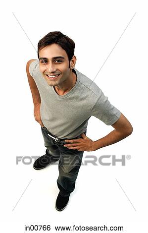 Stock Photograph - Young man looking at camera, hands on hip. Fotosearch