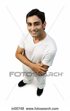 Young man looking up at camera, arms crossed View Large Photo Image Stock Photo - Young man looking up at camera, arms crossed. Fotosearch