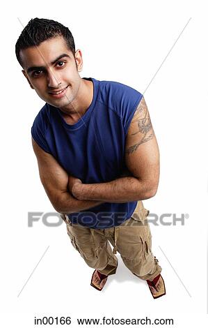 Young man looking up at camera, arms crossed View Large Photo Image Stock Photograph - Young man looking up at camera, arms crossed. Fotosearch