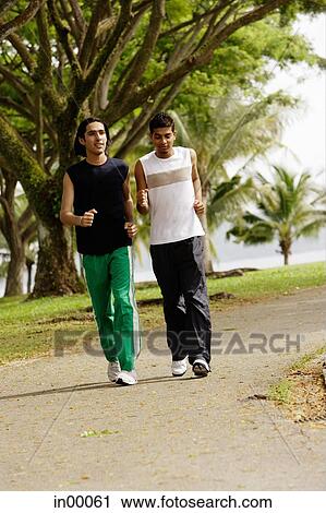 Young men jogging in park View Large Photo Image Stock Image - Young men jogging in park. Fotosearch