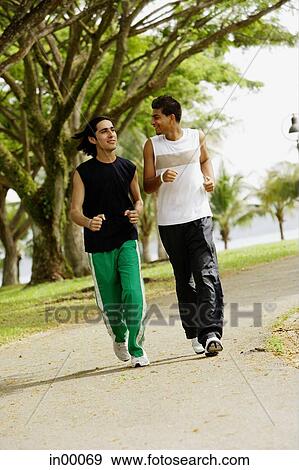 Young men jogging in park View Large Photo Image Stock Photo - Young men jogging in park. Fotosearch