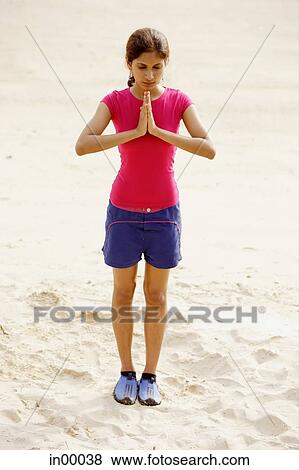 Young woman at the beach, standing, hands together View Large Photo Image Stock Photo - Young woman at the beach, standing, hands together. Fotosearch