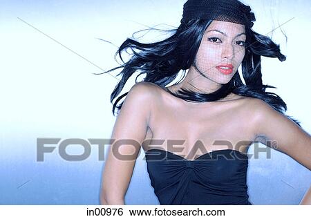 Stock Photograph - Young woman, fishnet covering face, looking at camera. Fotosearch