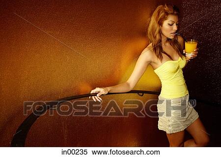 Young woman holding drink, holding on to staircase railing View Large Photo Image Stock Photography - Young woman holding drink, holding on to staircase railing. Fotosearch
