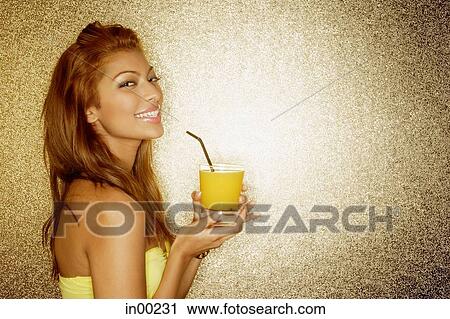 Young woman holding drink, looking at camera, portrait View Large Photo Image Stock Image - Young woman holding drink, looking at camera, portrait. Fotosearch
