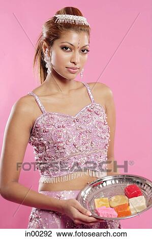 Young woman in Indian costume, holding a tray of Indian sweets View Large Photo Image Stock Image - Young woman in Indian costume, holding a tray of Indian sweets. Fotosearch