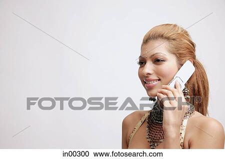 Young woman in Indian costume, using mobile phone, head shot View Large Photo Image Stock Image - Young woman in Indian costume, using mobile phone, head shot. Fotosearch