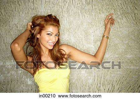 Young woman in tube top, hand on head, smiling at camera View Large Photo Image Stock Image - Young woman in tube top, hand on head, smiling at camera. Fotosearch
