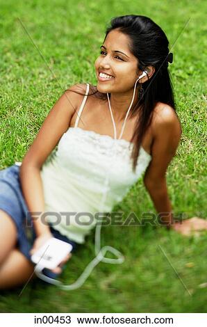 Young woman listening to music with headphones, portrait View Large Photo Image Stock Image - Young woman listening to music with headphones, portrait. Fotosearch