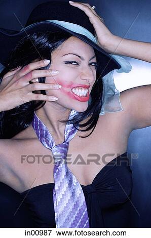Young woman, wearing hat and tie, grimacing and smearing lipstick View Large Photo Image Stock Photo - Young woman, wearing hat and tie, grimacing and smearing lipstick. Fotosearch