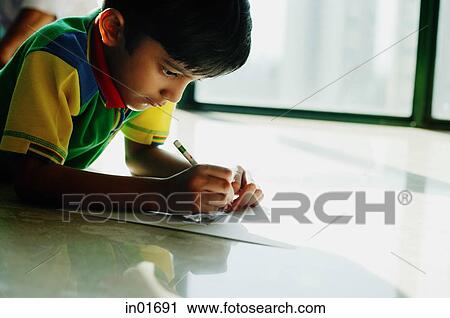 Boy lying on floor, drawing with crayons View Large Photo Image Stock Image - Boy lying on floor, drawing with crayons. Fotosearch