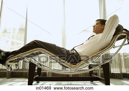 Businessman reclining on chair View Large Photo Image Stock Photo - Businessman reclining on chair. Fotosearch