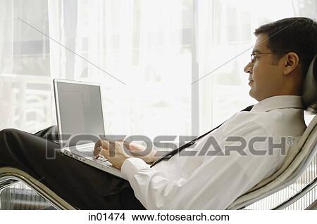 Businessman using laptop View Large Photo Image Picture - Businessman using laptop. Fotosearch