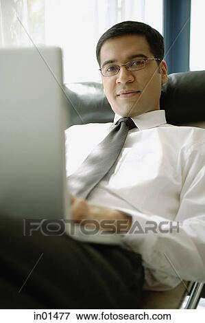 Businessman with laptop, looking at camera View Large Photo Image Stock Photo - Businessman with laptop, looking at camera. Fotosearch