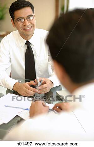 Businessmen sitting across from each other View Large Photo Image Stock Photo - Businessmen sitting across from each other. Fotosearch