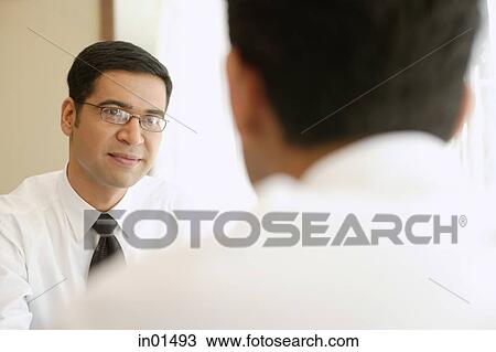 Stock Image - Businessmen sitting opposite each other. Fotosearch