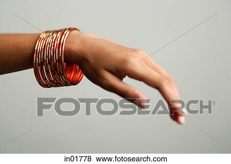 Stock Photo - Close-up of woman's hand with bangles. Fotosearch