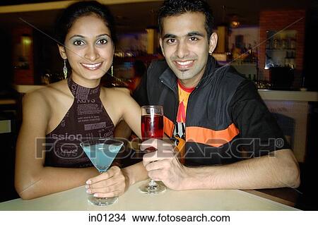 Couple in a club with drinks, smiling at camera View Large Photo Image Picture - Couple in a club with drinks, smiling at camera. Fotosearch