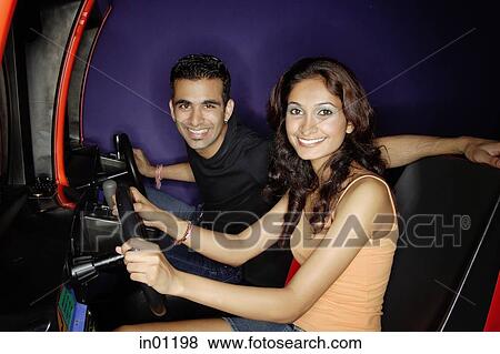 Couple in a video game arcade, playing games, smiling at camera View Large Photo Image Stock Photo - Couple in a video game arcade, playing games, smiling at camera. Fotosearch