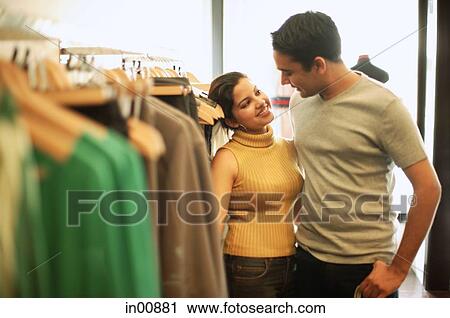 Couple in clothing store, looking at each other View Large Photo Image Stock Image - Couple in clothing store, looking at each other. Fotosearch
