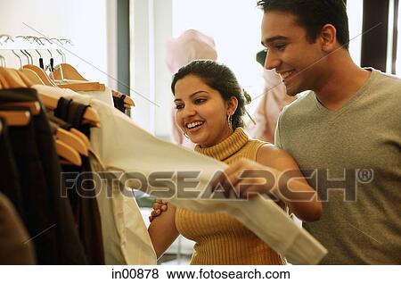 Couple looking at clothes in shop View Large Photo Image Stock Photo - Couple looking at clothes in shop. Fotosearch