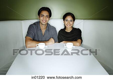 Couple sitting side by side looking at camera View Large Photo Image Stock Image - Couple sitting side by side looking at camera. Fotosearch