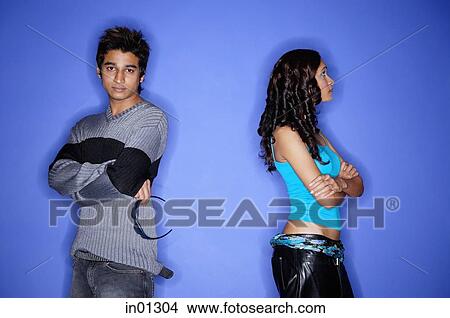 Picture - Couple standing apart against blue wall. Fotosearch