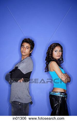 Couple standing apart looking at camera View Large Photo Image Stock Photograph - Couple standing apart looking at camera. Fotosearch