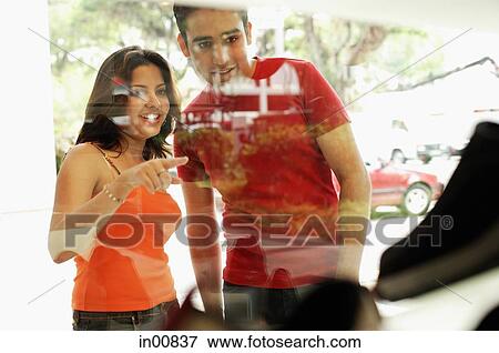 Couple standing outside shop window, looking at display View Large Photo Image Stock Photo - Couple standing outside shop window, looking at display. Fotosearch