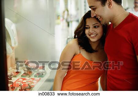 Couple standing side by side, looking at window display View Large Photo Image Stock Image - Couple standing side by side, looking at window display. Fotosearch