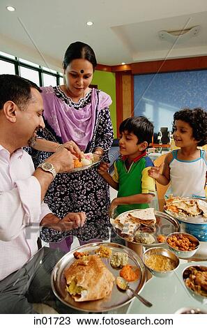 Stock Image - Family of four having a meal at home. Fotosearch