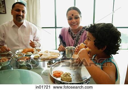 Stock Image - Family of three sitting down to a meal. Fotosearch