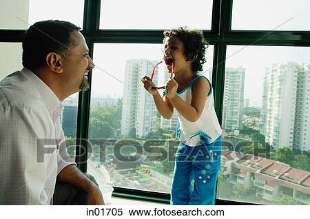 Father and daughter looking at each other, daughter holding sunglasses, laughing View Large Photo Image Stock Photography - Father and daughter looking at each other, daughter holding sunglasses, laughing. Fotosearch