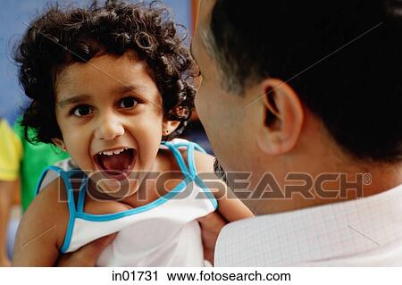 Stock Image - Father carrying daughter, over the shoulder view. Fotosearch