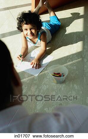 Girl lying on floor, smiling at her father View Large Photo Image Stock Photo - Girl lying on floor, smiling at her father. Fotosearch