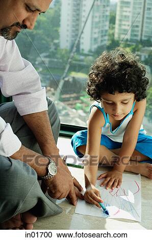Stock Image - Girl sitting on floor drawing with crayons and paper, father next to her. Fotosearch