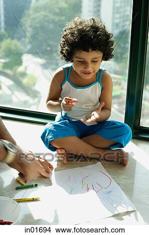 Girl sitting on floor with crayons and paper, fathers hands in foreground View Large Photo Image Picture - Girl sitting on floor with crayons and paper, fathers hands in foreground. Fotosearch