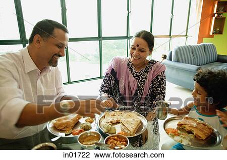 Stock Photo - Family of three having a meal at home. Fotosearch - Search Stock Photography, Print Pictures, Images, and Photo Clip Art