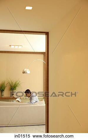Man at home, sitting in living room, reading a newspaper View Large Photo Image Stock Photography - Man at home, sitting in living room, reading a newspaper. Fotosearch