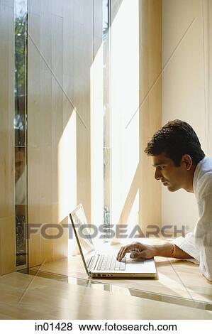 Stock Photo - Man at home, using laptop. Fotosearch