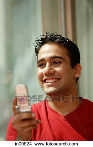 Picture - Man holding mobile phone, smiling. Fotosearch